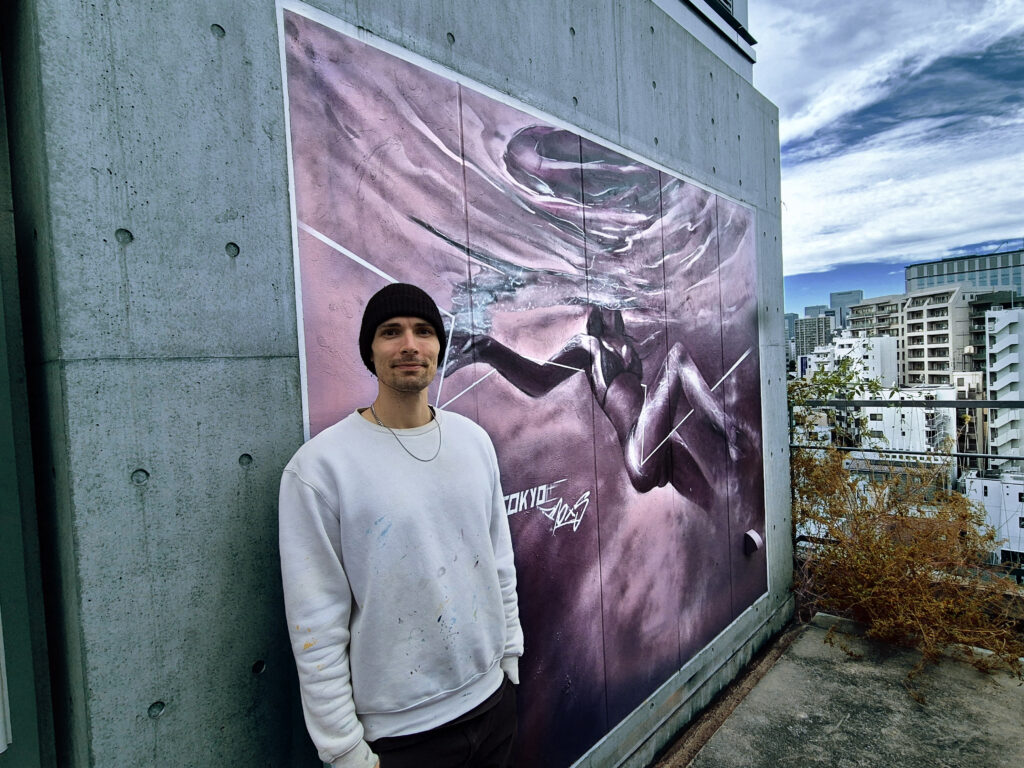 Porträtfoto Künstler RoxS vor seinem Werk in Tokio Japan.